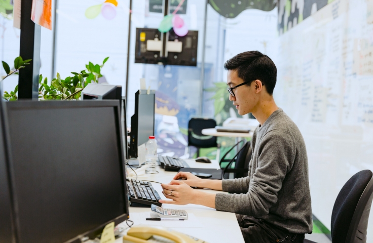 Man with glasses sitting at desktop booking a consultation with TELT Services at UNSW